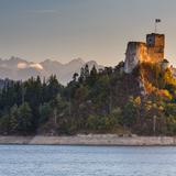 Zamek na wzgórzu nad jeziorem, w tle Tatry.