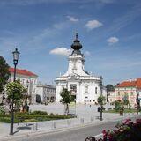 Główny plac w Wadowicach z widoczną bazyliką o białej fasadzie z wieżą.