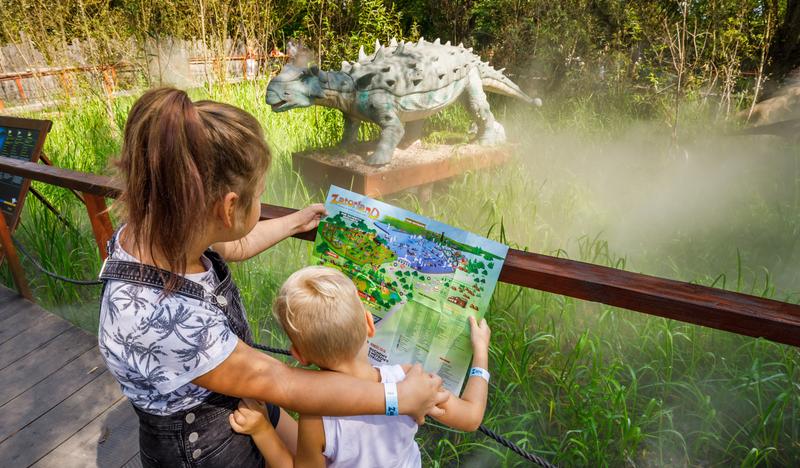 Na zdjęciu można zobaczyć chłopczyka i dziewczynkę zwiedzających Park Ruchomych Dinozaurów w Zatorze.