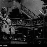 Archiwalne zdjęcie dyrygenta przed orkiestrą, na pierwszym planie wiolonczelista