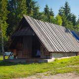 W centralnej części stoi drewniana Bacówka Andrzeja Pabina w Rdzawce. Obok chaty znajdują się sprzęty gospodarstwa domowego, natomiast za ogrodzeniem znajduje się las.