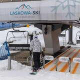 Snowboardzista na dolnej stacji wyciągu krzesełkowego Laskowa-Ski.