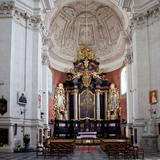 Duży, czarny ołtarz główny ze złoceniami w prezbiterium murowanego kościoła w półokrągłym wykuszu.  Przed nim drewniane ławy i krzesła.