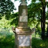 Kamienny nagrobek w kształcie obelisku na cmentarzu.